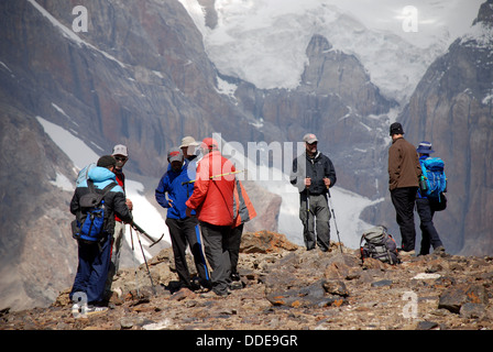 trekkers rest below a hanging glacier in the Fann mountains of Tajikistan Stock Photo