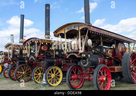 Row of steam traction engines displayed at the Great Dorset Steam Fair UK with blue sky above Stock Photo