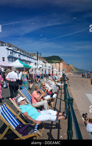 Holidaymakers relaxing on the esplanade during Sidmouth Folk Festival, Devon, UK Stock Photo