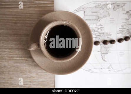 artwork in grunge style, cup of coffee, coffee beans and political map of the world Stock Photo