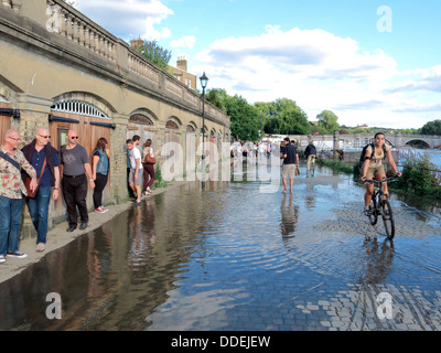 People avoiding high tide over spill from the Thames River in Richmond, London Stock Photo