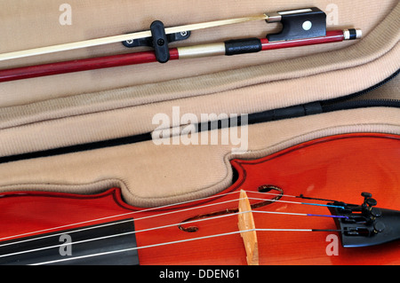 Viola in its case showing f-holes, bridge, fingerboard, tailpiece with fine tuners and bow Stock Photo