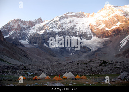 A trekking camp below a hanging glacier high in the fann mountains of Tajikistan Stock Photo