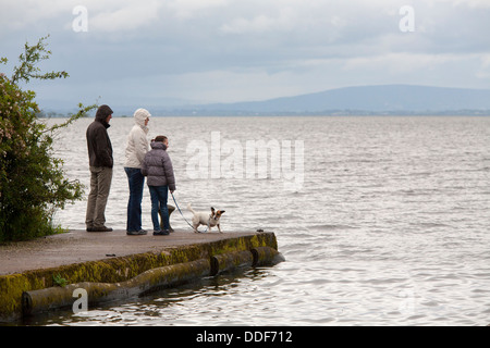 A family look across the lake while walking the trail at Lough Neagh Discovery and Conference Centre in Lurgan, Northern Ireland Stock Photo