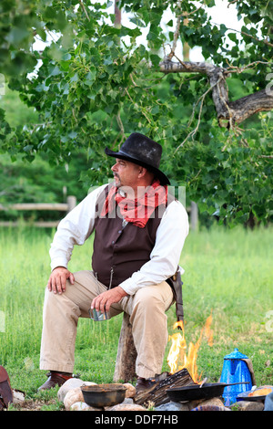 A cowboy preparing and eating breakfast at his campfire Stock Photo