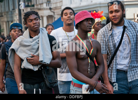 Group of youths walking down street towards Notting Hill Carnival West london Stock Photo