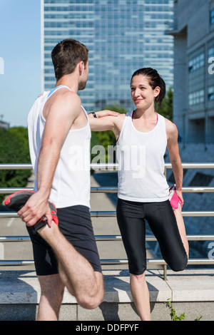 Couple exercising and stretching muscles before sport activity in city Stock Photo