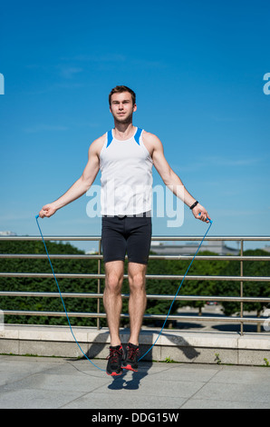 Young sport man exercising - jumping with skipping rope Stock Photo