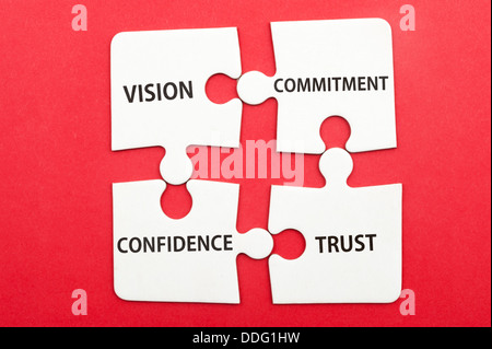 Business teamwork concept of vision, commitment, confidence, trust written on group of jigsaw puzzle pieces Stock Photo