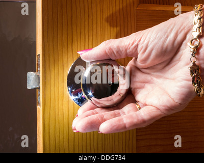 Mature Woman's Hand Turning Door Knob (Series 1 of 3) Stock Photo