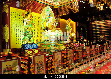 A beautifully handcrafted Bodhisattva Avalokitesvara sits upon an elaborate lotus throne  (The Buddha Tooth Relic Temple) Stock Photo
