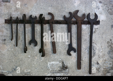 old metal iron spanners hanging on a stone wall in an old forge Stock Photo