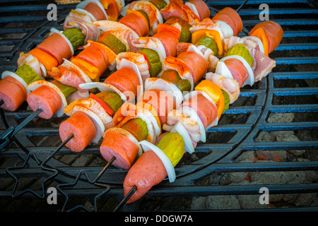 BBQ grill grate with a healthy mix of meat and vegetables on skewers Stock Photo