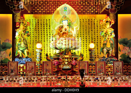 A beautifully handcrafted Bodhisattva Avalokitesvara sits upon an elaborate lotus throne  (The Buddha Tooth Relic Temple) Stock Photo