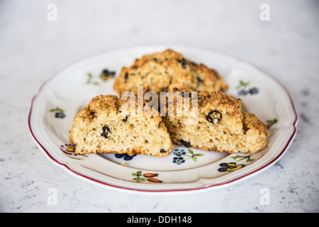 Rock cakes - take your pick! A traditional British teatime small fruit cake made with currents or raisins on a flowery plate Stock Photo