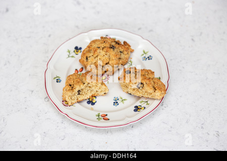 Rock cakes - take your pick! A traditional British teatime small fruit cake made with currents or raisins on flowery plate Stock Photo
