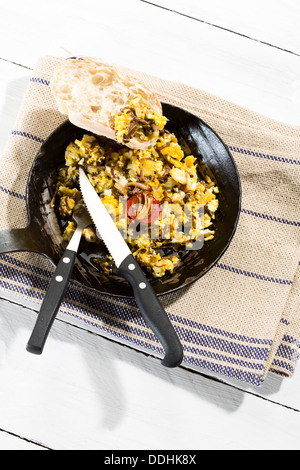 Scrambled eggs with enoki mushrooms and onions in pan, close up Stock Photo
