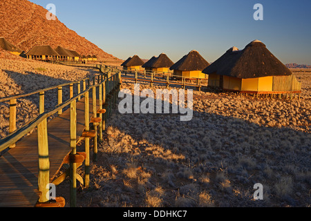 Chalets or cabins of the Sossus Dune Lodge in the evening light Stock Photo