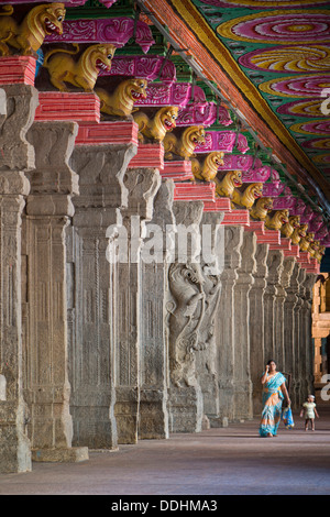 Woman with a child in a hall with brightly painted pillars, mythical creatures, Meenakshi Amman Temple or Sri Meenakshi Stock Photo