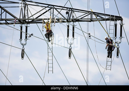 High-voltage service technicians installing a new high voltage power line Stock Photo