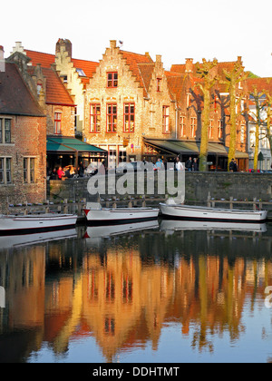 Guild houses with stepped gables being reflected in a canal with boats Stock Photo