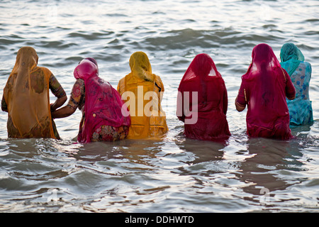 Hindu pilgrims, women in colourful saris taking a holy bath om the sea before sunrise, at the Ghat Agni Theertham Stock Photo