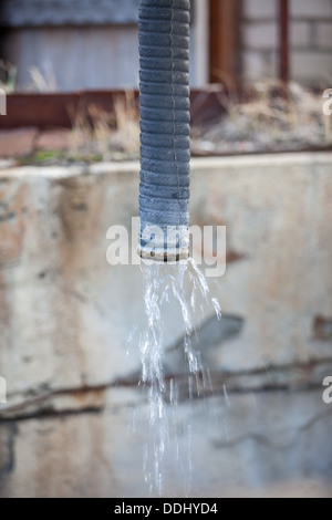 Dirty sewage water flowing from a pipe Stock Photo