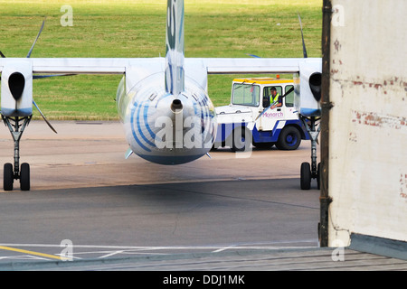 Flybe Dash 8 aeroplane being towed from a maintenance hangar at the old Elmdon Airport site at Birmingham International Airport Stock Photo