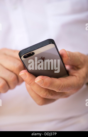 Senior man using Apple iphone 5 Stock Photo