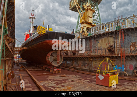 Ship for repairs in large floating dry dock. Stock Photo