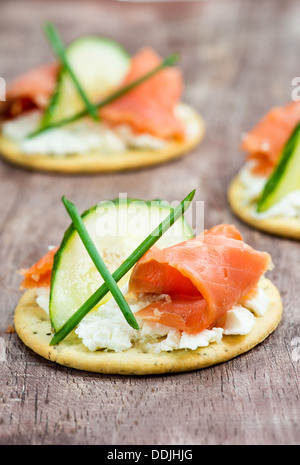 Canapes with smoked salmon, cucumber and cream cheese, selective focus, closeup Stock Photo