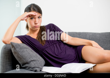 Woman with a dissatisfied expression reading Stock Photo
