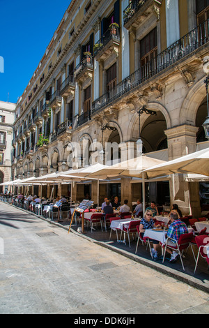 Outdoor cafe restaurant with tourists seated in Plaza Real or Plaça Reial, Barcelona, Catalonia, Spain Stock Photo