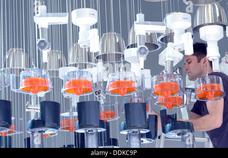 Berlin, Germany. 04th Sep, 2013. An employee hans up the kirchen appliances by Bosch at the fairground in Berlin, Germany, 04 September 2013. The IFA takes place from 06 September to 11 September. Photo: Rainer Jensen/dpa/Alamy Live News Stock Photo