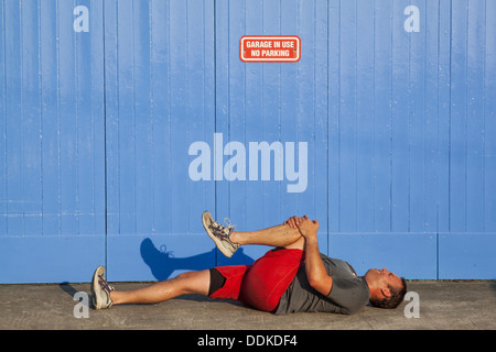 England, Cornwall, Marazion, Jogger with Cramp in front of No Parking Sign Stock Photo