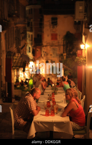 People eating at night outside in the quaint streets of Corfu Town, Greece Stock Photo