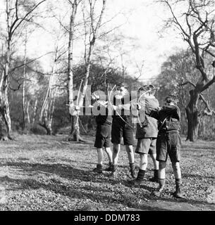 Boys shooting with bows and arrows in Hampstead, London, c1950s. Artist: Henry Grant Stock Photo