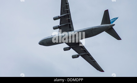 Antonov 124-100 UR-82073 jumbo jet cargo transporter plane flying underbelly landing lights on flaps down cloudy sky Stock Photo