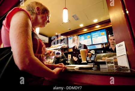 A Barista serving coffee to a customer, Costa Coffee, Grand Arcade shopping centre, Cambridge UK Stock Photo