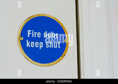 Sign telling people to keep an entrance shut to stop a blaze spreading around a house by being stopped at the fire door Stock Photo