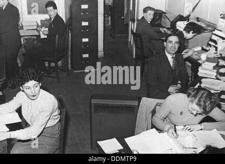 1950s 1960s DISTRACTED OFFICE SECRETARY FILE CLERK LEANING ON ELBOW ON  METAL FILING CABINET LOOKING INTO FILE FOLDER - o1206 DEB001 HARS GROWNUP  ONE PERSON ONLY COPY SPACE HALF-LENGTH LADIES GROWN-UP FOLDER