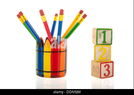 A collage of colorful pencils in a cup next to three 1-2-3 cubes isolated over a white background Stock Photo