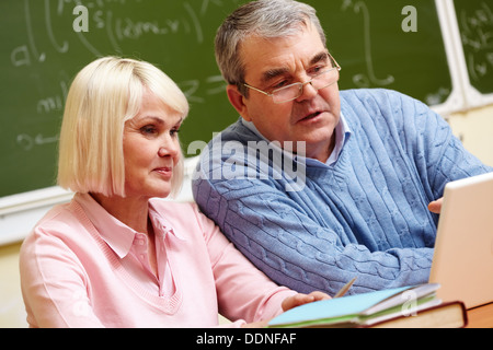 Elderly people using modern technologies for studying Stock Photo