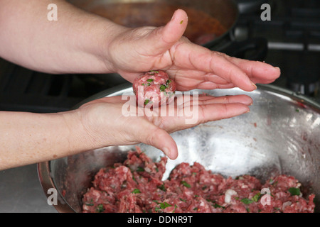 Cooking Moroccan meatballs in tomato sauce forming a meatball Stock Photo