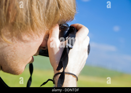 Young Photographer taking a photograph using a DSLR camera outdoors Stock Photo