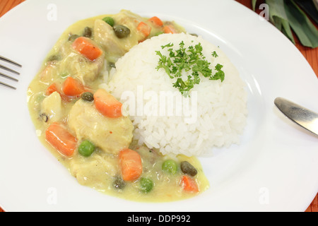 Chicken fricassee with rice, peas, capers and parsley Stock Photo