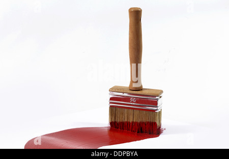 brush with red paint on white plane Stock Photo