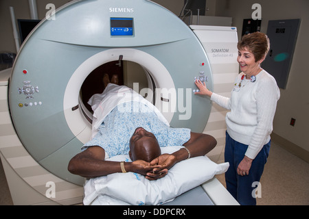 Tech works with a patient in a MRI scanner. Stock Photo