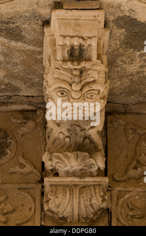 Stone carvings under a balcony on an old building in Ortigia, Syracuse, Sicily, Italy Stock Photo