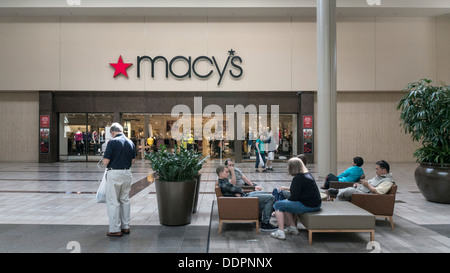 people relax in comfortable chairs in skylit atrium of Alderwood Mall outside Macys department store entrance Lynnwood Stock Photo